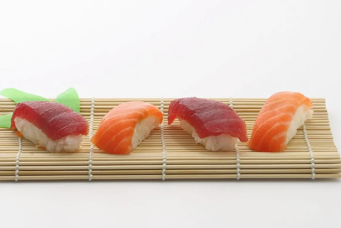 Four pieces of nigiri sushi on a bamboo mat